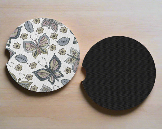 White butterfly-and-floral coaster beside its black underside