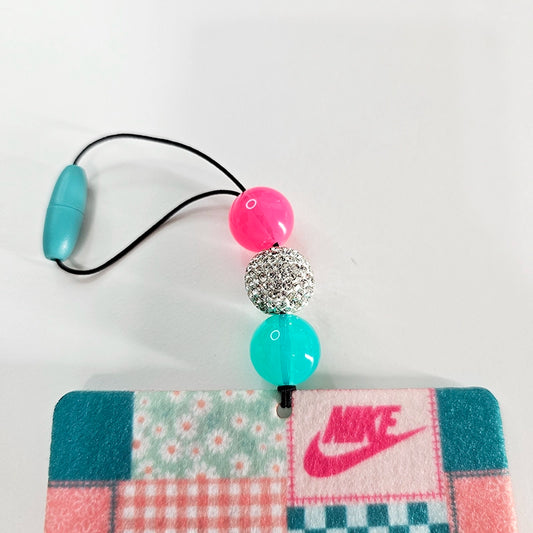Close-up of patchwork felt air freshener and pink and turquoise beads