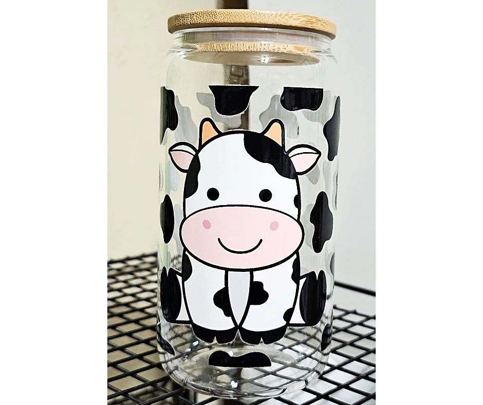 16oz glass can tumbler featuring a charming baby cow amidst a backdrop of playful cow print 