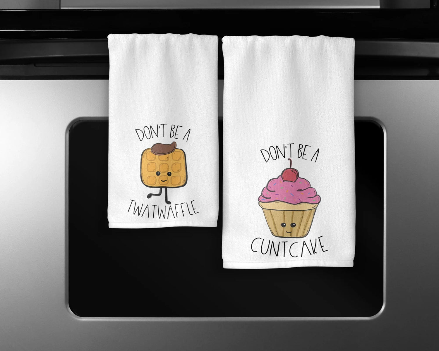 Set of kitchen towels featuring cute food cartoon images: one with a cupcake and the words 'Don't be a cuntcake', and the other with a waffle and the words 'Don't be a twatwaffle'