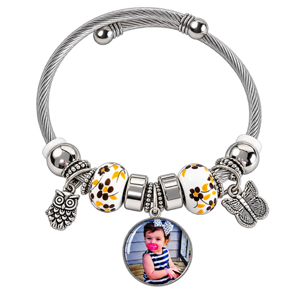 A Memory to Wear personalized photo charm bracelet with silver-tone cable band, yellow floral beads, and owl and butterfly charms.