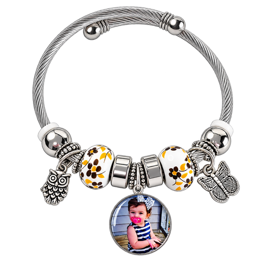 A Memory to Wear personalized photo charm bracelet with silver-tone cable band, yellow floral beads, and owl and butterfly charms.