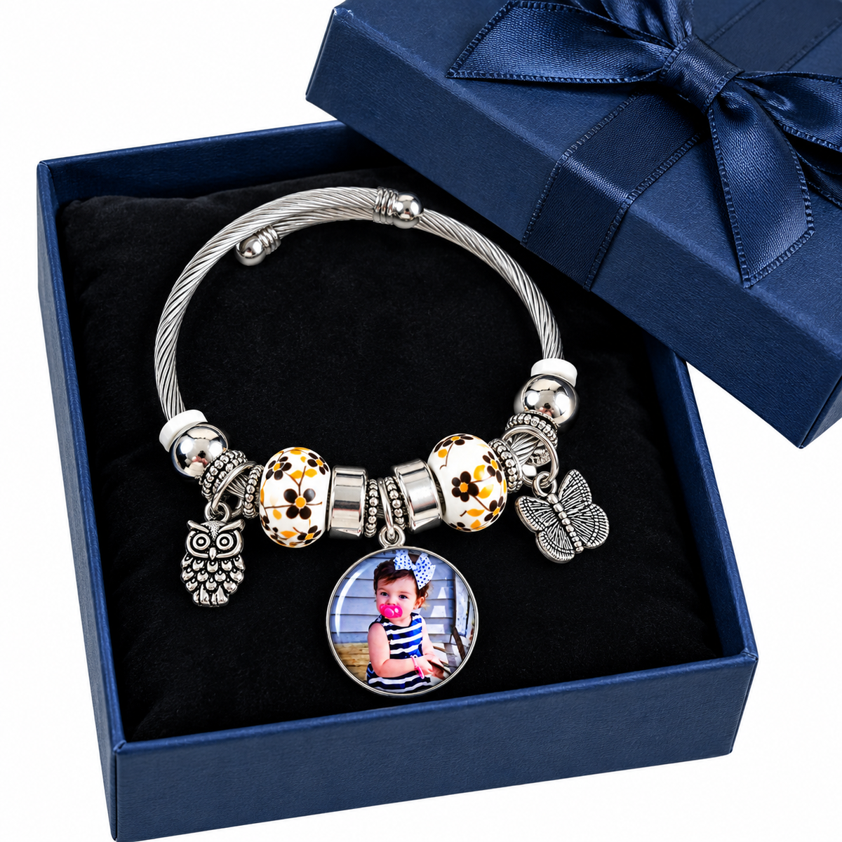 A Memory to Wear personalized photo bracelet displayed in an open navy gift box with a matching ribbon-tied lid.