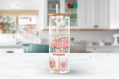 A 25 oz clear glass tumbler with a retro floral design and the words 'best fucking mom' in a bold groovy font