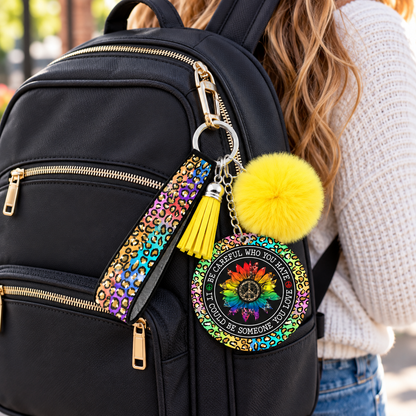 Be Careful Who You Hate wristlet keychain hanging from a backpack