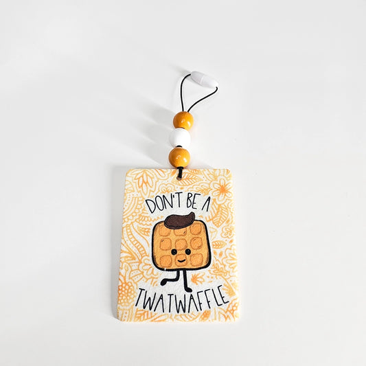 Twatwaffle cartoon waffle felt air freshener with golden floral accents front view