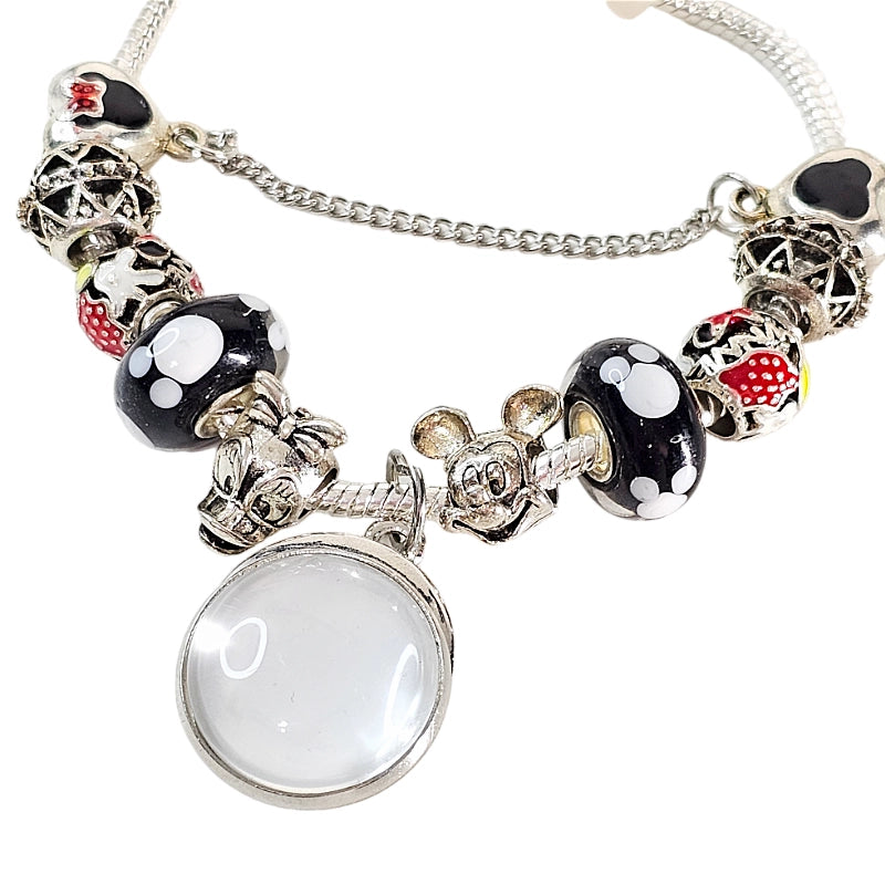 Close-up of Enchanted Memories bracelet with a blank round photo charm, mouse-themed beads, silver-tone character accents, and safety chain.