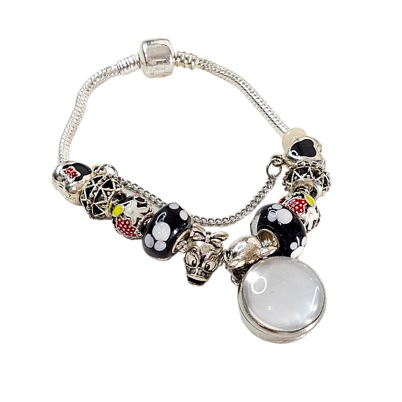 Full view of Enchanted Memories bracelet with a blank round photo setting, silver-tone band, and black, white, and red mouse-themed beads.