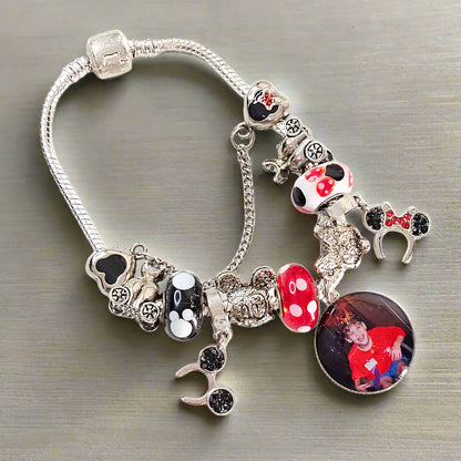 Angled view of Enchanted Moments photo charm bracelet on a gray surface, showing colorful mouse-themed beads and a silver-tone safety chain.