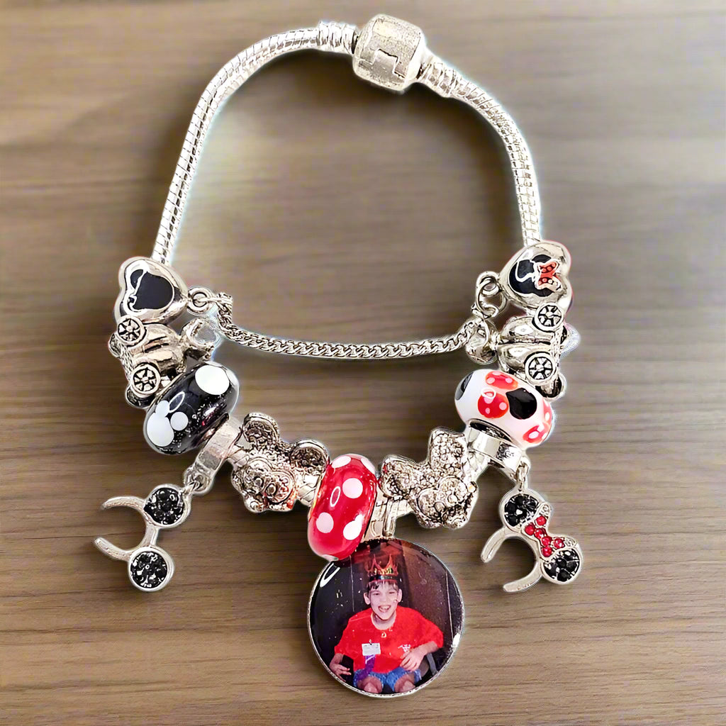 Front view of Enchanted Moments personalized bracelet with a child’s photo, polka-dot beads, silver-tone accents, and dangling mouse-ear charms.