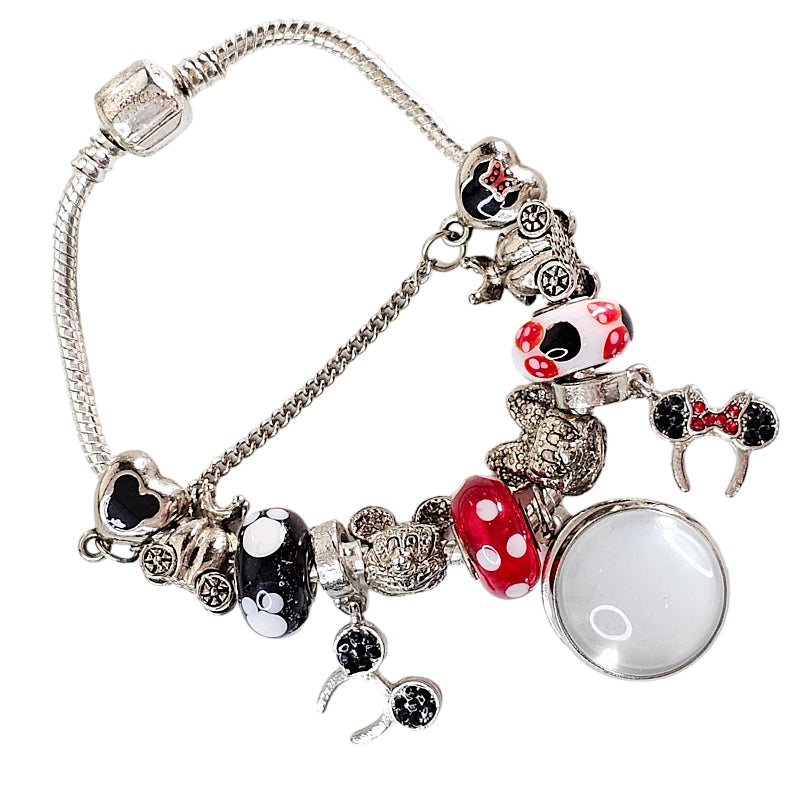 Angled Enchanted Moments bracelet with a blank round photo charm, red and black polka-dot beads, mouse-ear charms, and safety chain.