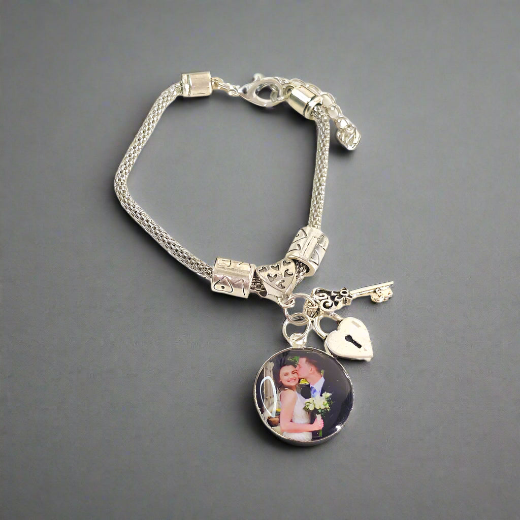 Keys to My Heart personalized bracelet displayed on gray with a round couple photo charm, heart-shaped lock, key charm, and extender chain.