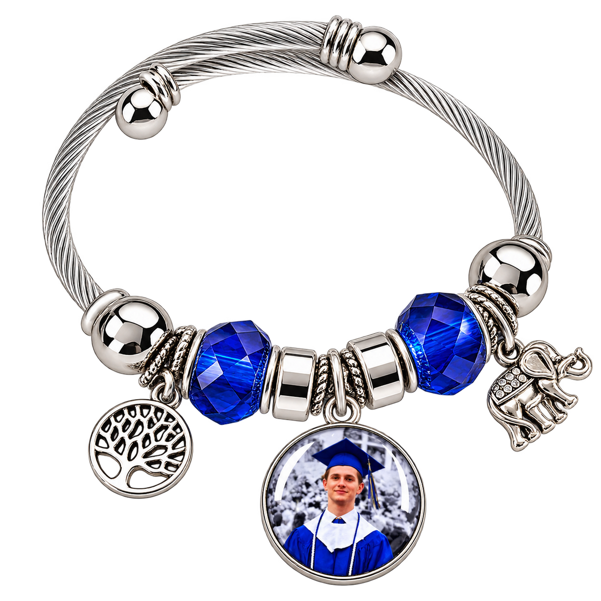 Angled view of Rooted in Memories personalized graduation photo bracelet with blue beads, a silver-tone cable band, and dangling tree and elephant charms.