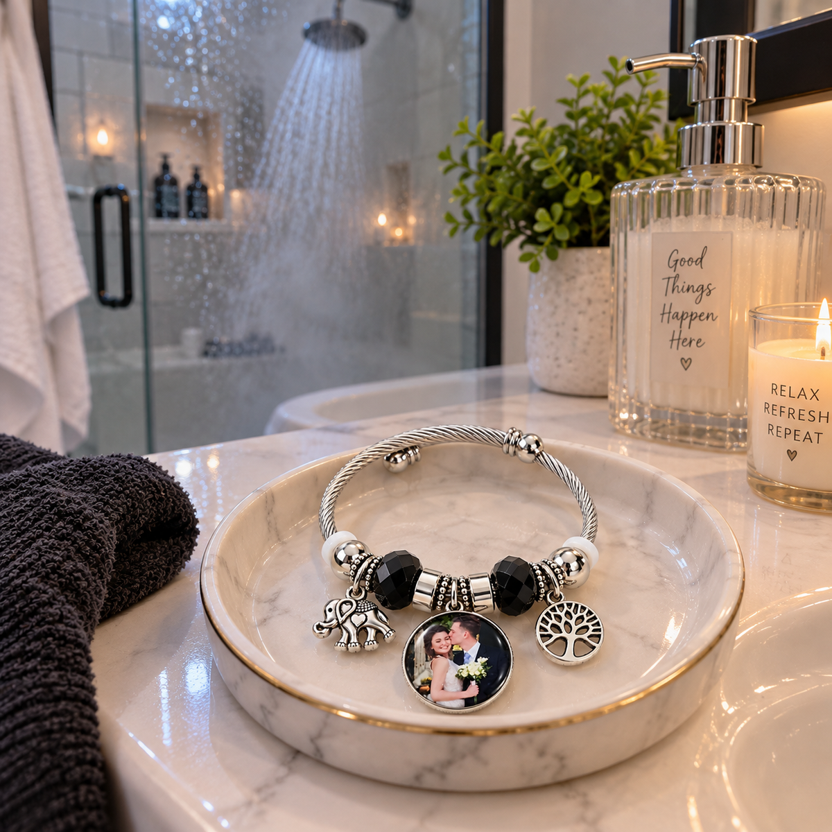 Black-and-silver photo bracelet displayed on a bathroom vanity