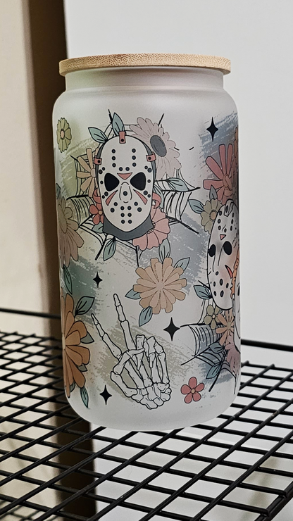 A 16oz glass tumbler featuring a blend of floral motifs and horror movie characters