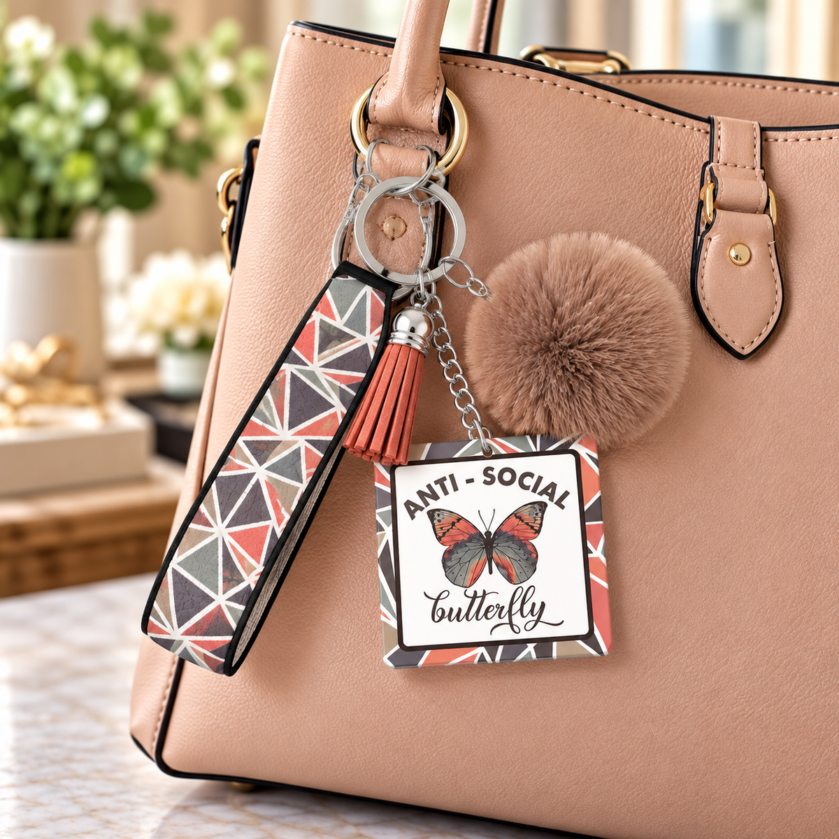 Butterfly wristlet keychain hanging from a tan purse