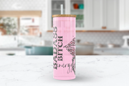 A 25oz clear glass tumbler with a pink leopard print skeleton design and the words 'Badass Bitch Energy' on it