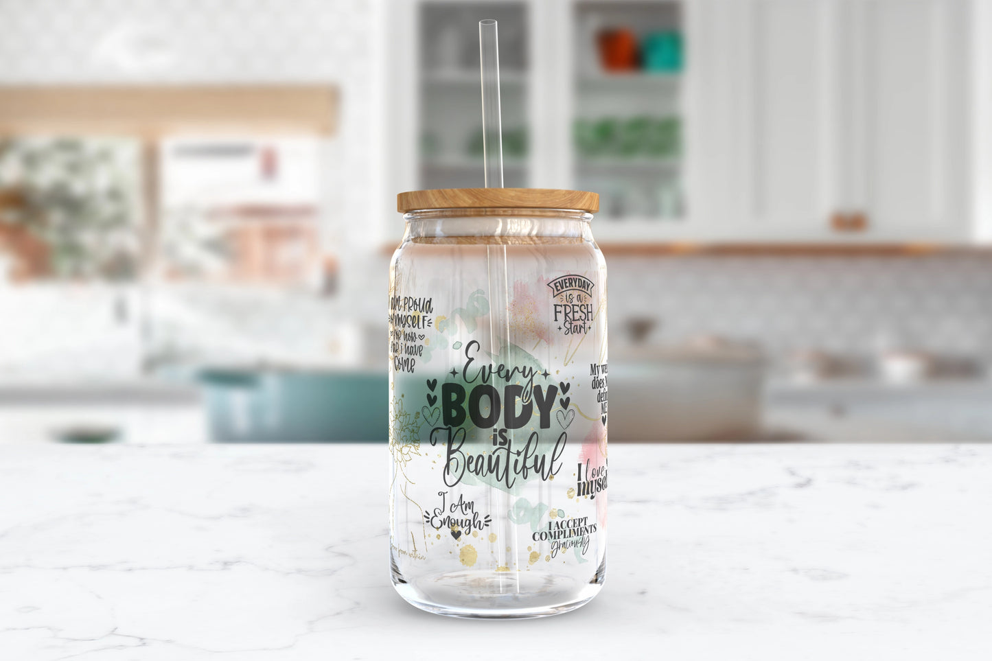 A 16oz clear glass tumbler adorned with inspirational self-love quotes and the words 'Every Body Is Beautiful'