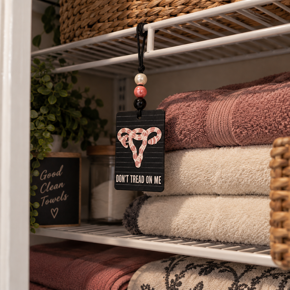 Women Belong in All Places beaded hanging air freshener, reverse side hanging in a linen closet.