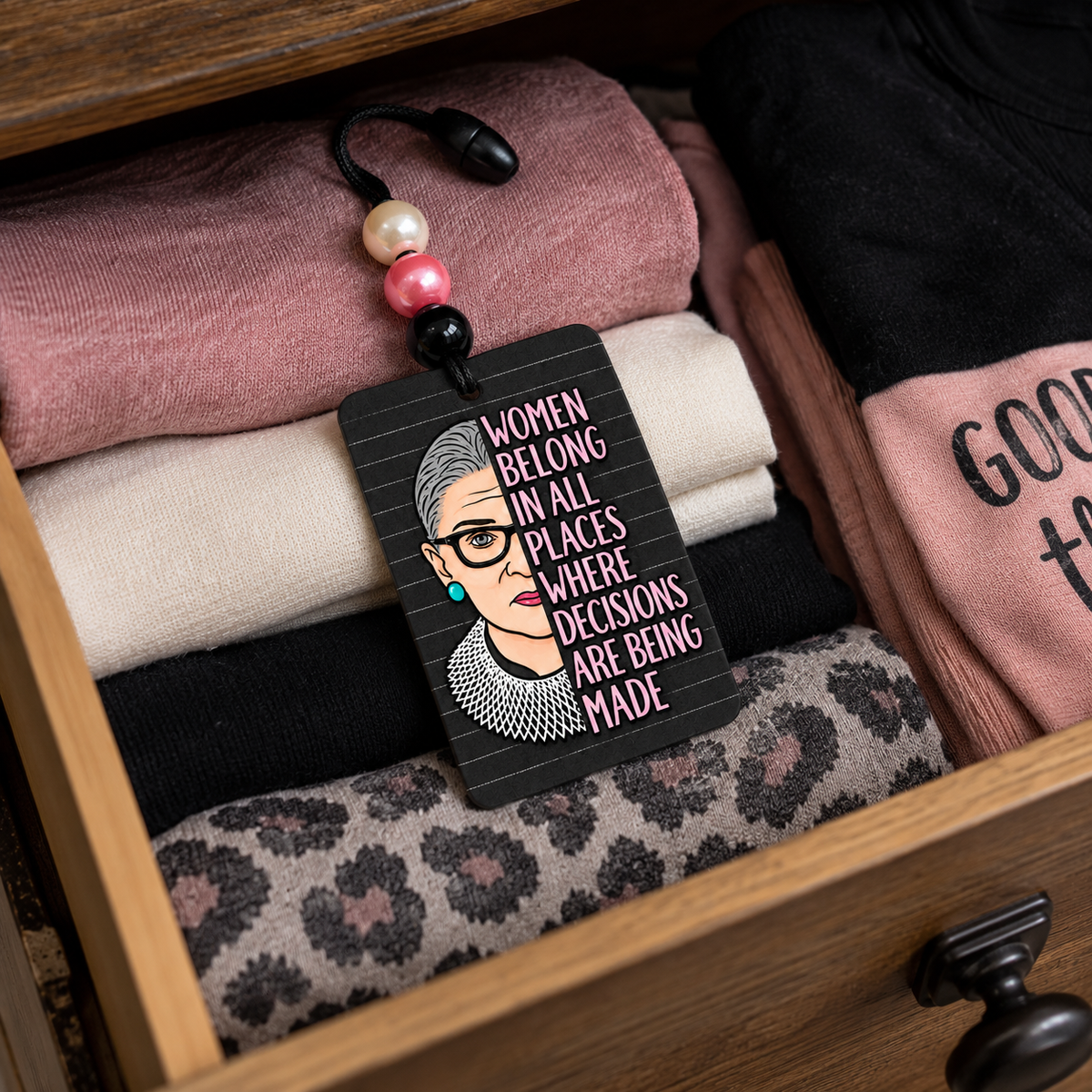 Women Belong in All Places beaded hanging air freshener, portrait side placed in a dresser drawer.