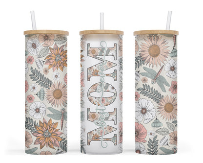 A 25oz frosted glass tumbler with a boho floral and dragonfly design, featuring the word 'MOM' in bold with 'best ever' written inside the middle of the word